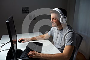 Man in headset playing computer video game at home photo