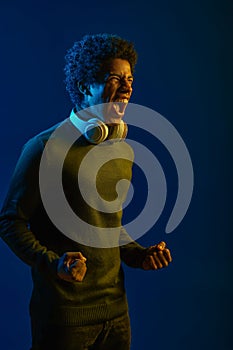 Man in headset screaming over dark studio background