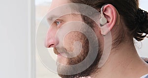 Man in hearing aid listening and shaking head
