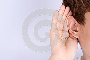 Man hearing loss or hard of hearing and cupping his hand behind his ear isolate grey background, Deaf concept