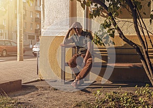 Man with heat stroke sitting on bench, tired of hot temperature, summer weather in city