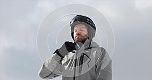 Man with helmet closing up soft shell jacket preparing for skiing.Mountaineering ski activity. Skier people winter sport