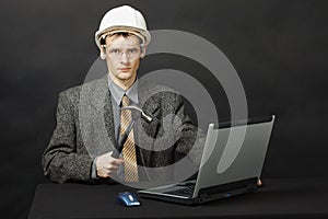Man in helmet with hammer repairs computer