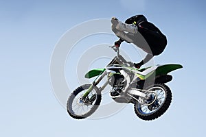 Man in a helmet performs a stunt in the air on a motorcycle