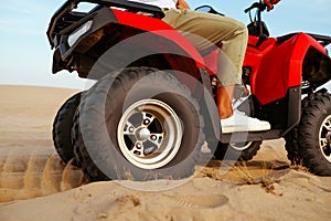 Man in helmet rides on atv in desert, action view