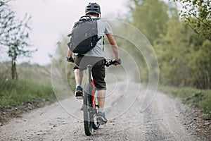 Man in helmet riding a bicycle at country road