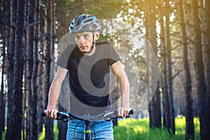 Man in a helmet riding on a mountain bike in the woods. Cyclist in motion. Concept of active and healthy lifestyle