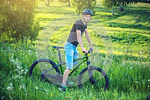 Man in a helmet riding on a mountain bike in the woods. Cyclist