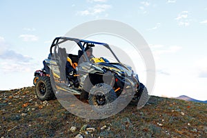 Man in helmet sitting on ATV quad bike in mountains