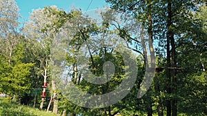 Man in Helmet is Sliding Down ZipLine in Adventure High Rope Park in Summer