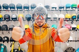 Man in helmet for snowboarding shows thumbs up