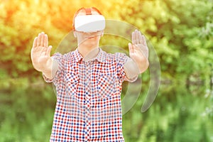 Man in helmet of virtual reality against the background of nature.Hands stop