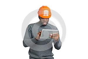 Man in helmet working on tablet.