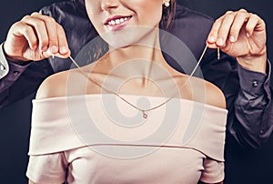 Man helping his girlfriend to try on a golden necklace. Gift for Valentines day.