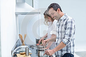 Man helping pregnant woman prepare food