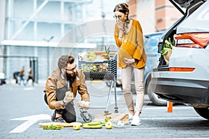 Man helping young pregnant woman near the supermarket