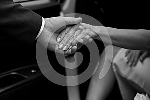 The man helps the girl out of the car. Hands close-up. Black and white version