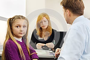 Man and her little daughter sit in office of realtor