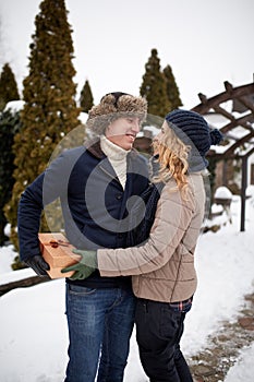 Man is hides box behind his back and going to give his woman a present on Valentine`s Day, Christmas or New Year