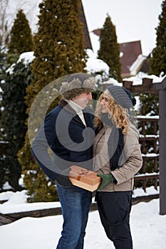 Man is hides box behind his back and going to give his woman a present on Valentine`s Day, Christmas or New Year