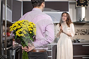 Man hiding behind the back bouquet of yellow spring flowers