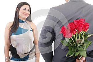 Man hiding bunch of red roses behind his back to surprise