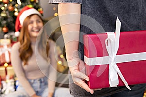 A Man Hiding a Christmas Present Behide to Surprise his Girlfriend