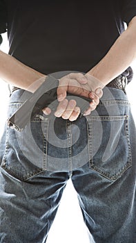 Man hiding gun behind his back