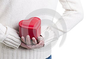 Man hiding a heart shaped box