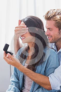 Man hiding wifes eyes to offer her an engagement ring