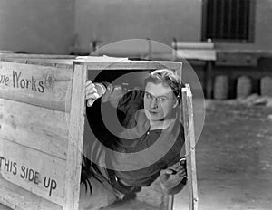 Man hiding in wooden crate