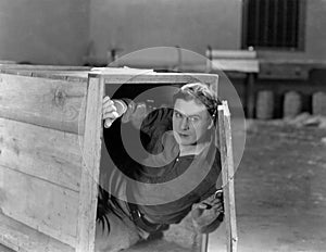 Man hiding in wooden crate