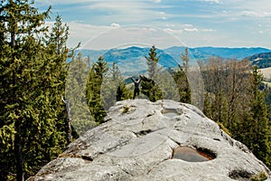 A man is high in the mountains against the sky, celebrating the victory, raising his hands up