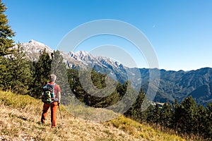 Man hiker is admiring the range mountains landscape