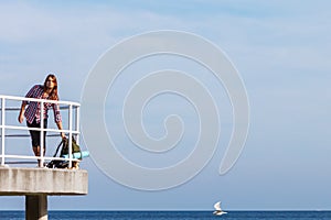 Man hiker with backpack on pier, sea landscape