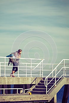 Man hiker with backpack on pier, sea landscape