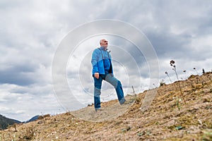 Man hiker enjoys snowdrops blooming at Carpathian mountains