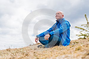 Man hiker enjoys snowdrops blooming at Carpathian mountains