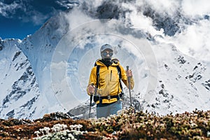 Man hiker going mountain track. Solo traveling with touristick backpack across mountains