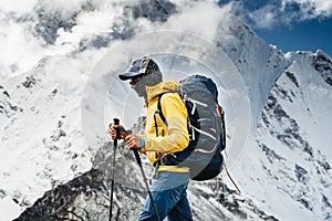 Man hiker going mountain track. Solo traveling with touristick backpack across mountains