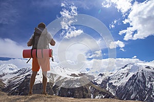 Man hiker greeting rich nature on the top of mountain