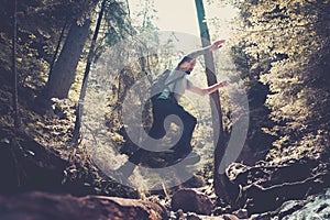 Man hiker jumping across stream