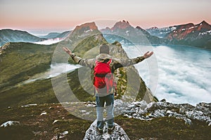 Man hiker raised hands exploring mountains of Norway