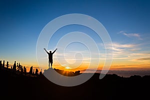 Man hiker silhouette with arms outstretched enjoy mountains photo
