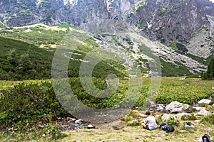 Muž turista sedí vo Veľkej Studenej doline na Slovensku počas zamračeného dňa