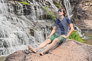 Man hiker, tourist on the background of Amazing Pongour Waterfall is famous and most beautiful of fall in Vietnam. Not