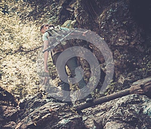 Man hiker walking across stream