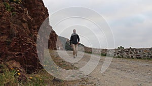 Man hiking along a road from Ceuta in Spain on a cloudy day