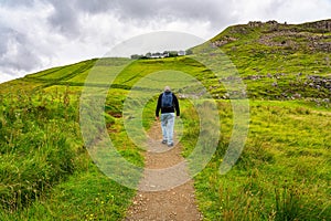 Man hiking down a path up the mountain on the Isle of Skye, Scotland.