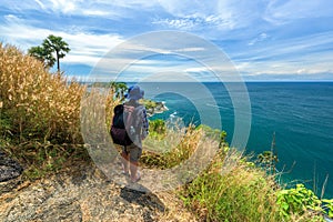 Man with hiking equipment walking at Phromthep cape viewpoint in Phuket